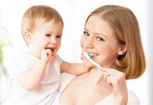 Знакомить ребенка с зубной щеткой нужно уже с первого зуба.
